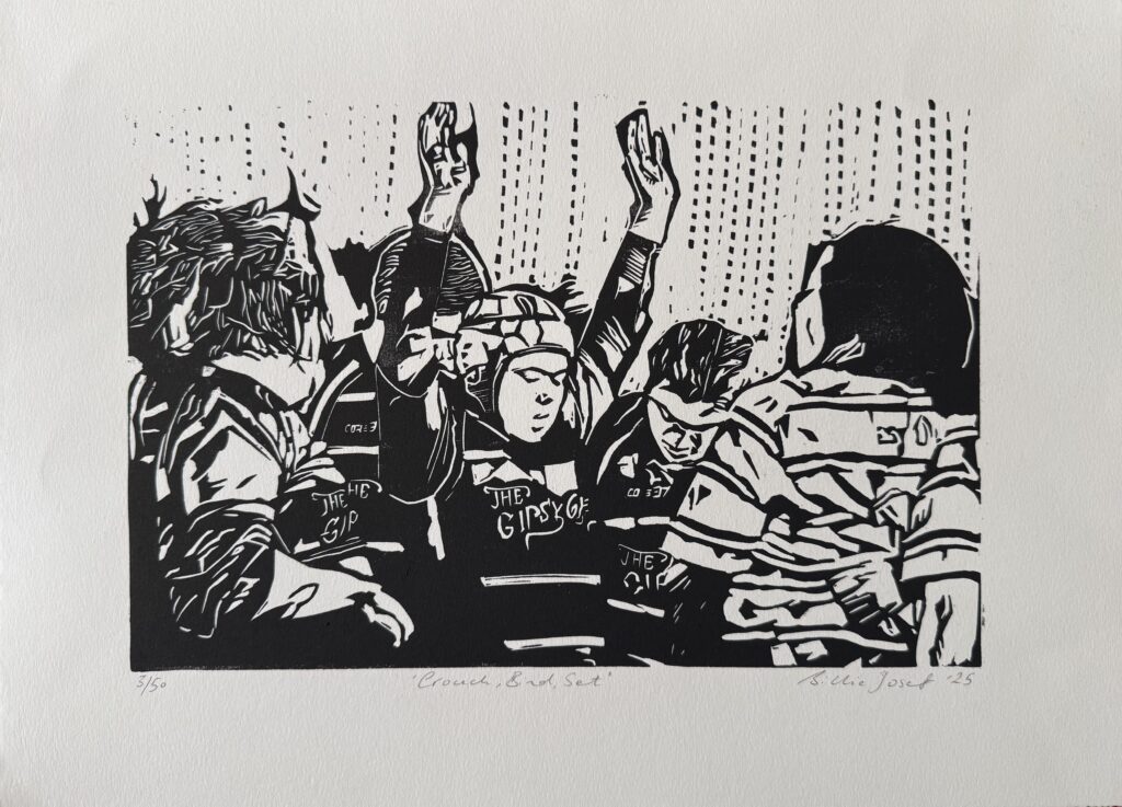 Crouch, bind, set. A women's rugby scrum preparing to engage with the opponents.